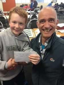 Gabriel with chess coach David proudly showing his winnings in the Chess Centre